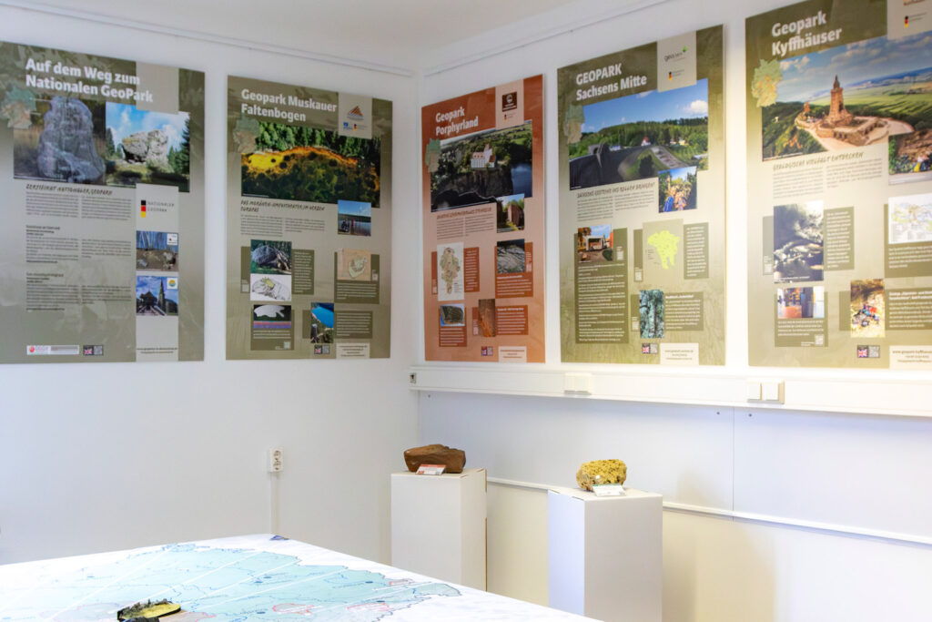 Ansicht der Ausstellung des Eiszeitmuseums. Man sieht im Hintergrund verschiedene Informationstafeln zu anderen Geoparks, im Vordergrund eine Karte, die sich über einen Tisch spannt.